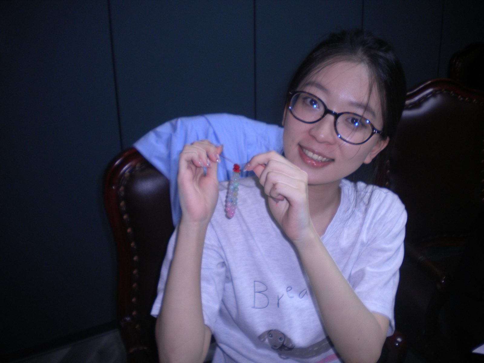 穿白色 T 恤的同学展示一小串彩色珠子